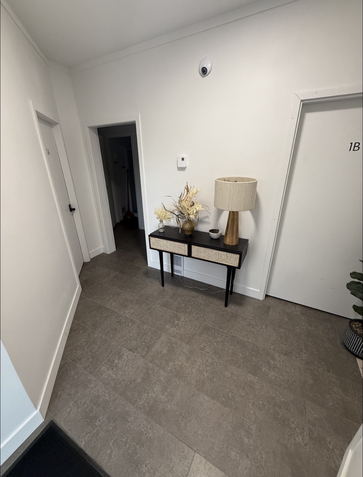 Common area with console table, lamp, and office 1B